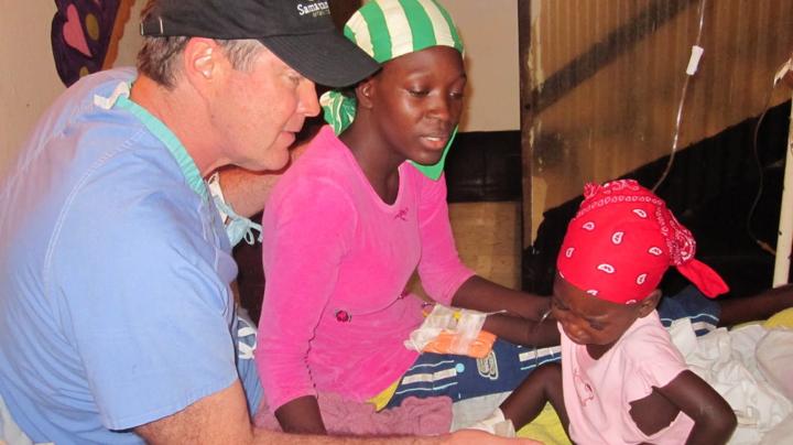 Dr Bill Frist attending a woman and her child in Haiti